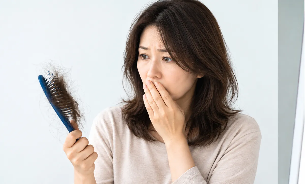 ブラシを手に髪の悩みを抱える女性